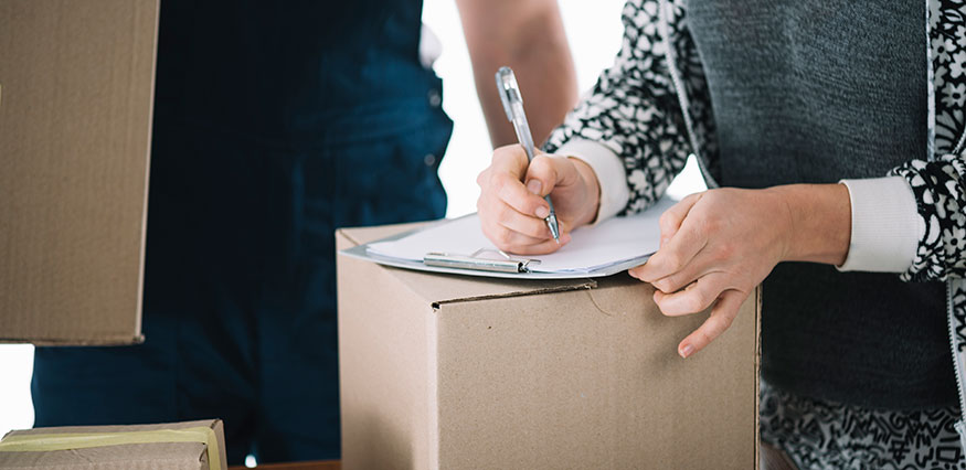 Femme signe un document pour son déménagement