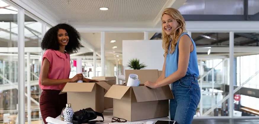 deux femmes remplissent des cartons pour un déménagement de bureaux