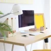Bureau en bois sur lequel est posé un ordinateur, de la décorations et des rangements