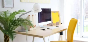 Bureau en bois sur lequel est posé un ordinateur, de la décorations et des rangements