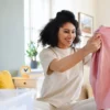 Femme en train de ranger ses vêtements dans sa chambre
